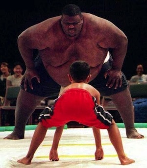 Big sumo facing a child