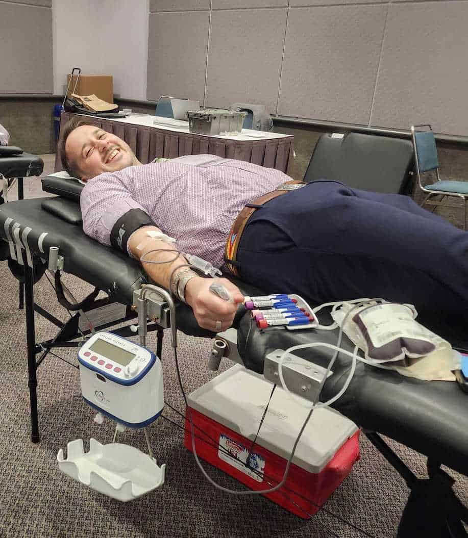 John laying on blood donation bed successfully giving his pint of life at ViVE 2024.